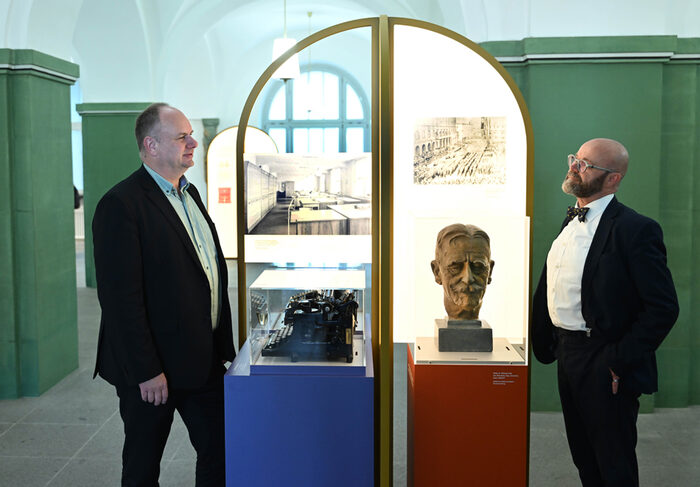 Foyer Goldene Pforte: Oberbüergemeister Dirk Hilbert und Prof. Thomas Kübler stehen vor zwei Ausstellungstücken.Im Hintergrund eine grüne Wand.