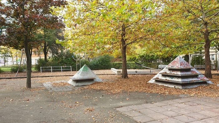 Platz mit kleinen Steinpyramiden und Bäumen im Herbst