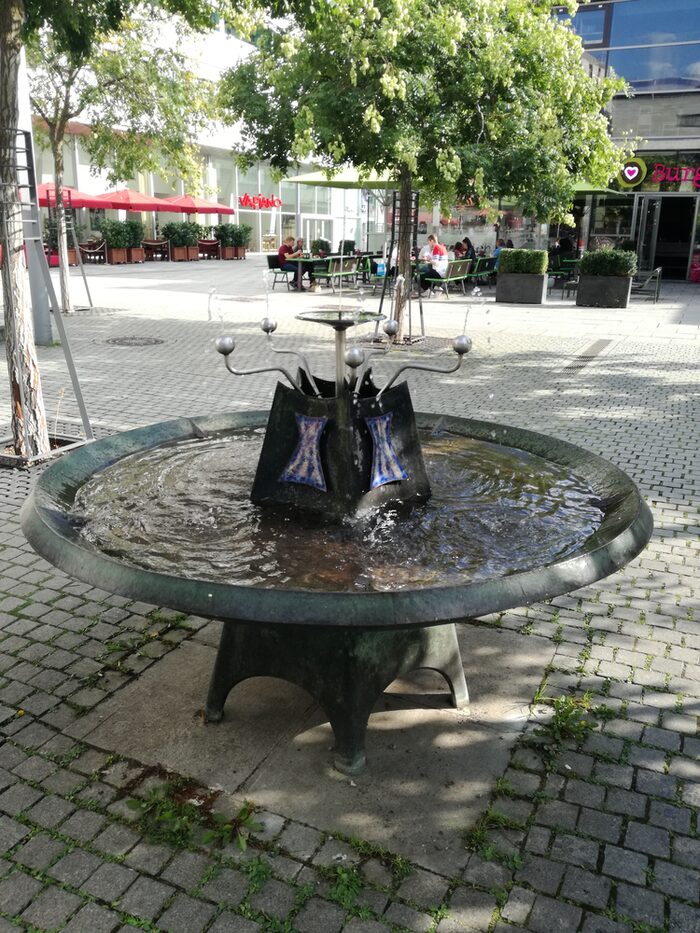 Trinkwasserbrunnen Prager Straße mit einem runden Wasserbecken und mehreren Düsen, aus denen man Wasser trinken oder eine Trinkflasche befüllen kann.