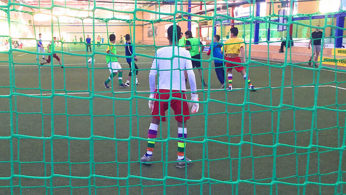 Fußballspieler in der Halle durch Tornetz betrachtet