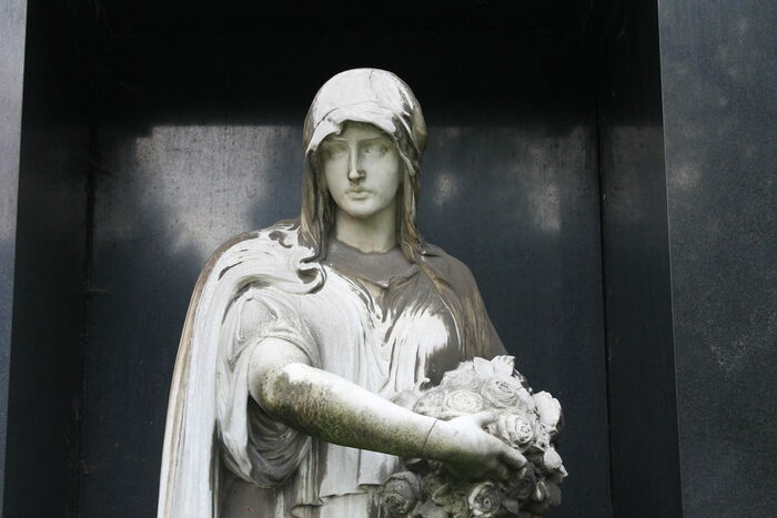 weibliche Steinfigur mit Rosen