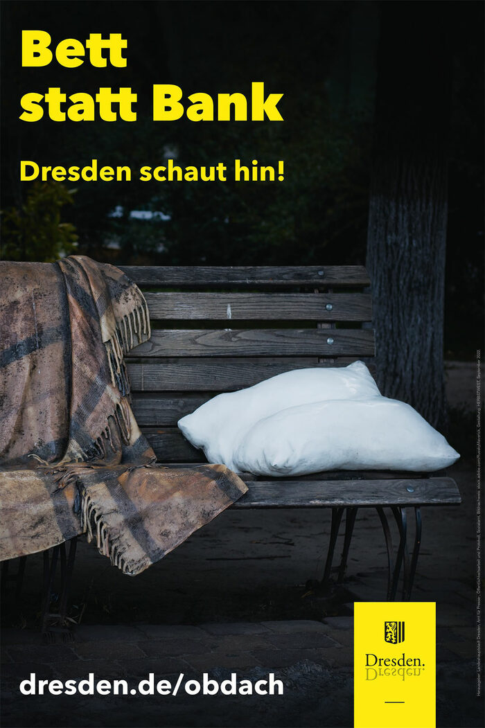 Plakatmotiv: Kissen und Decke liegen auf einer Bank; Titel: Bett statt Bank, Dresden schaut hin!