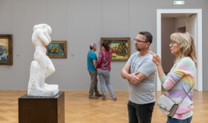 Вид на Альбертинум с картинами и скульптурами и посетители смотрят на них.