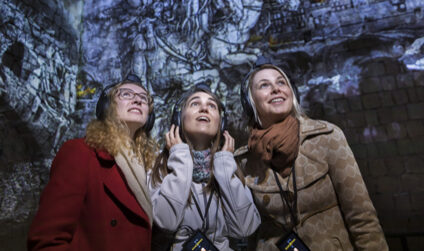 Three women with headphones listen to the story of Dresden Fortress.