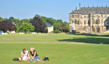 Zwei Freundinnen auf einer der vielen Wiesen im Großen Garten, im Hintergrund das Palais