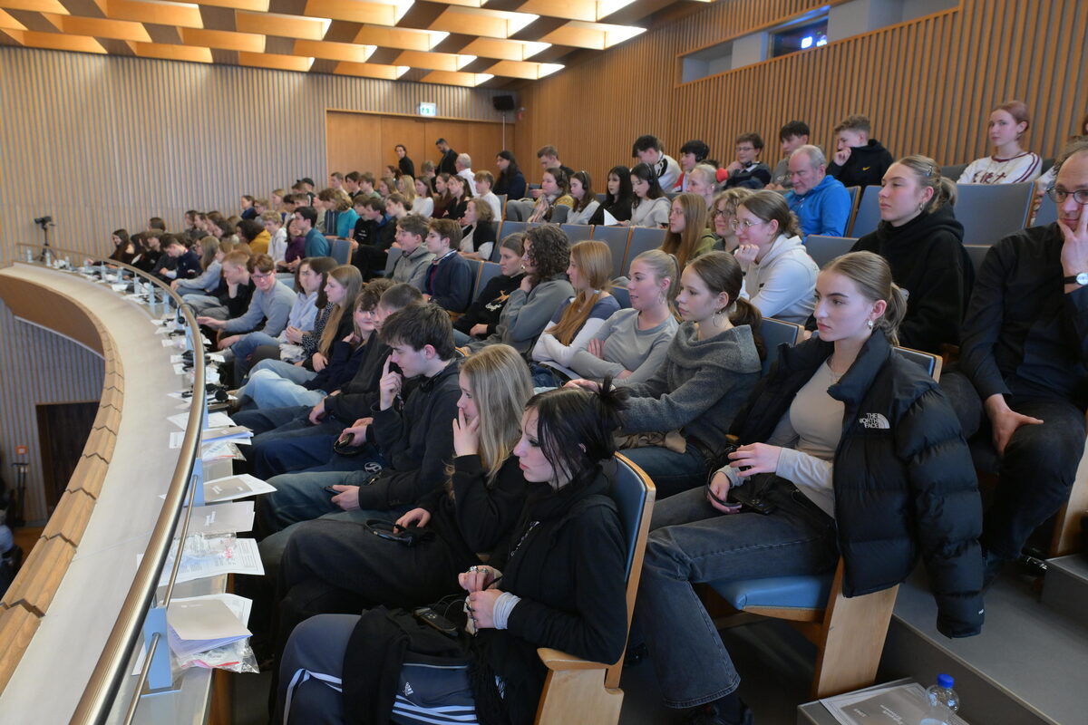 Blick auf mehrere Menschen sitzend auf einer Empore