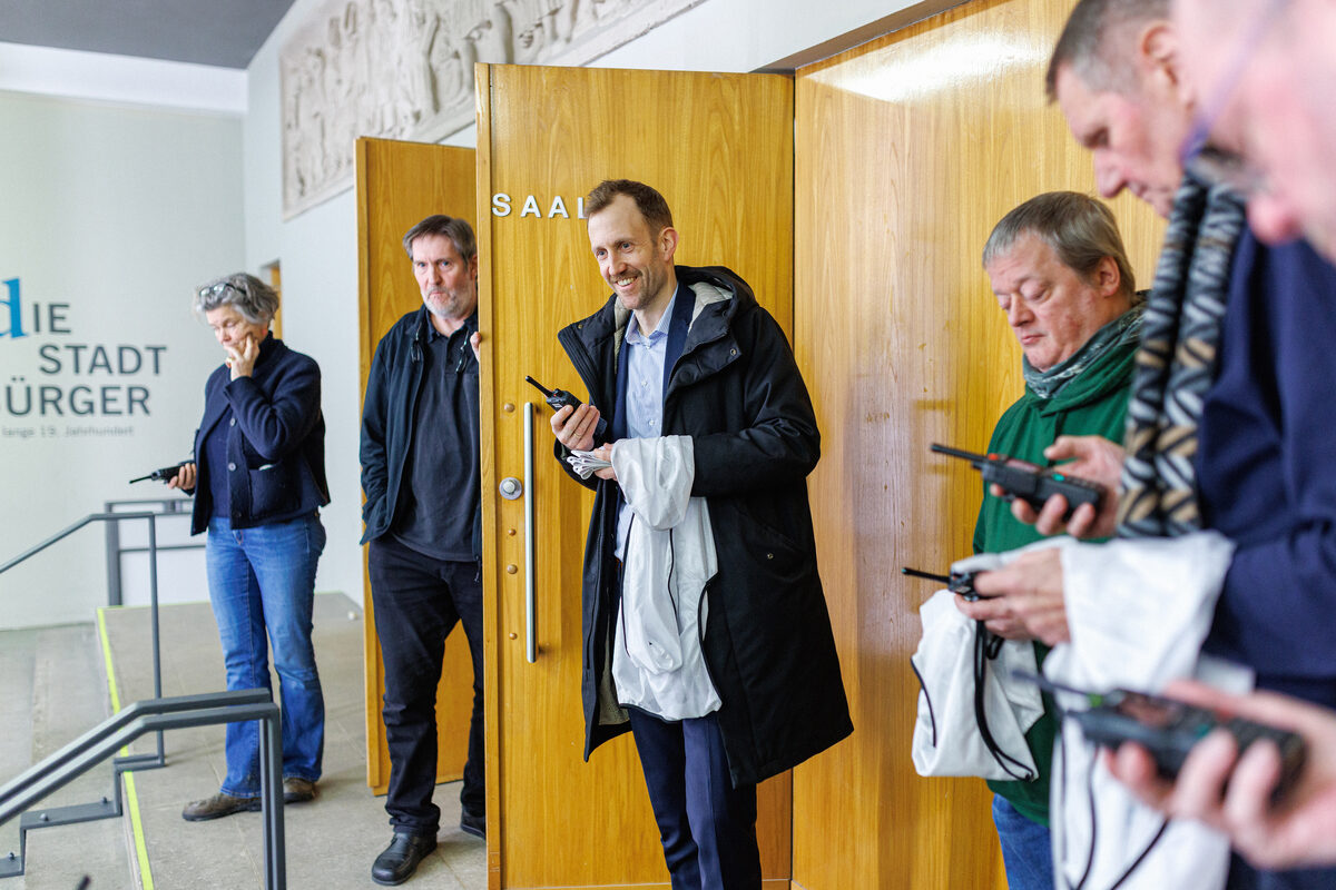 Menschen stehen vor offener Tür und halten Wakie Takies in den Händen.