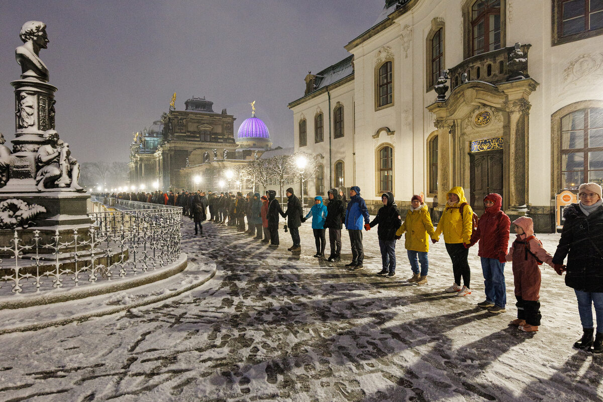 Menschen stehen im Schnee Hand in Hand