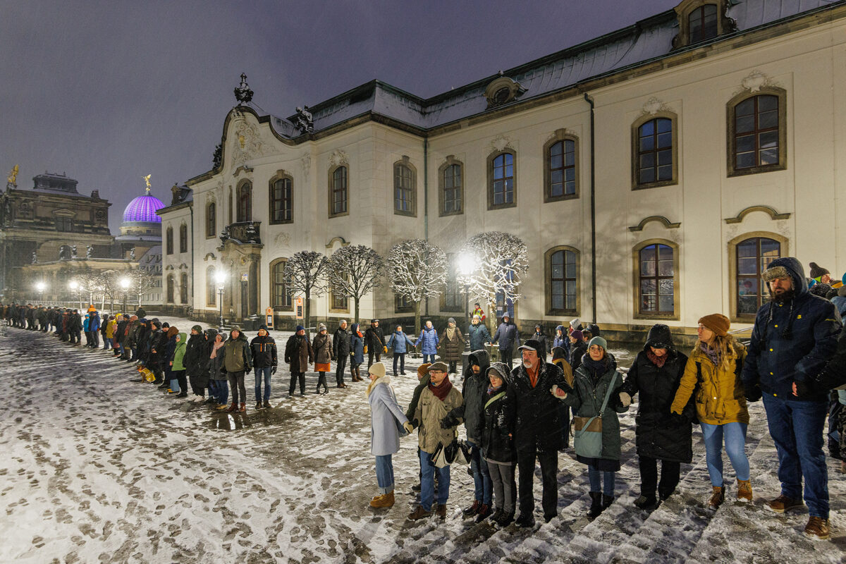 Menschen stehen im Schnee Hand in Hand