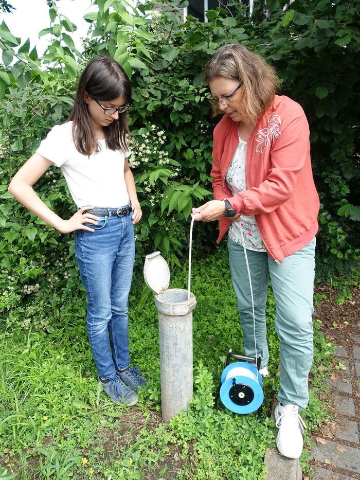 Eine Schülerin hilft bei einer Grundwassermessung dem Umweltamt.