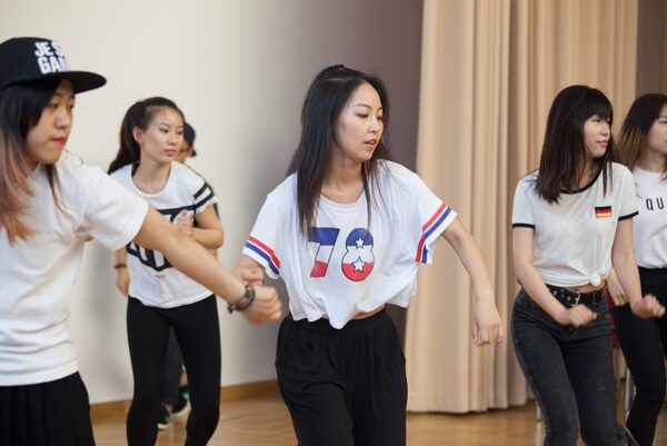 Mehrere Frauen in weißen T-Shirts beim Tanzen