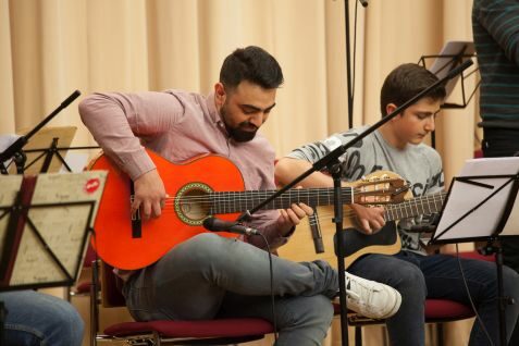 Ein mann und ein Junge beim Gitarre spielen