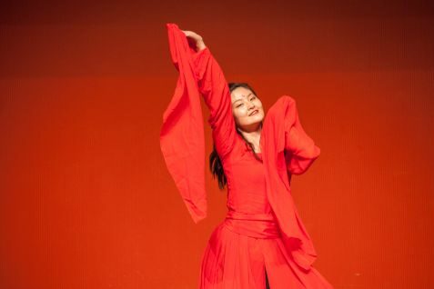 Tänzerin des Shudao-Studios im roten Gewand während ihres Auftritts