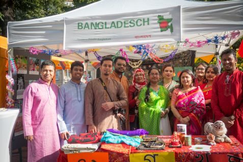 mehrere Mitglieder der Bangladesch Community Dresden in bunten Gewändern an ihrem Stand des Straßenfests