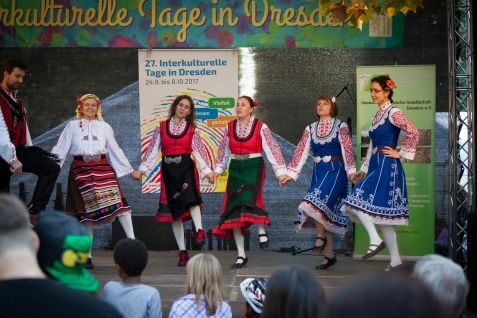 Fünf Frauen und ein Mann führen einen traditionellen Tanz auf der Bühne auf