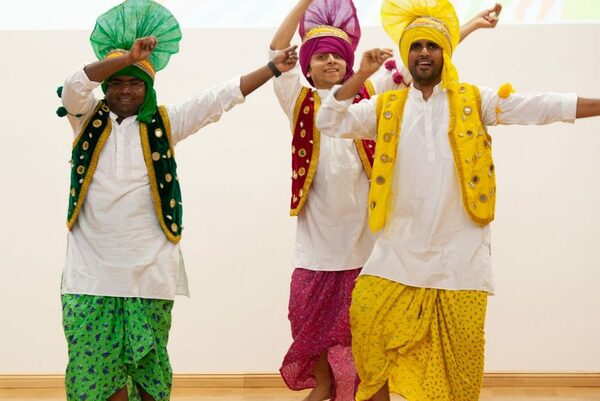 Drei Tänzer der Tanzgruppe "Sanskriti" in bunten Gewändern