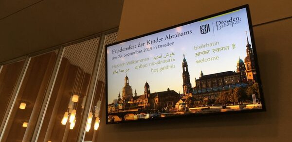Bildschirm mit Dresden im Hintergrund und Texten aus verschiednen Sprachen