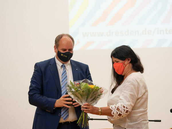 Marita Schieferdecker-Adolph steht mit einem Blumenstrauß neben Oberbürgermeister Dirk Hilbert