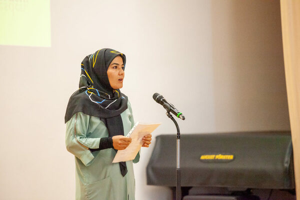 Somaiya Hussaini referiert ein Gedicht am Mikrofon auf der Bühne