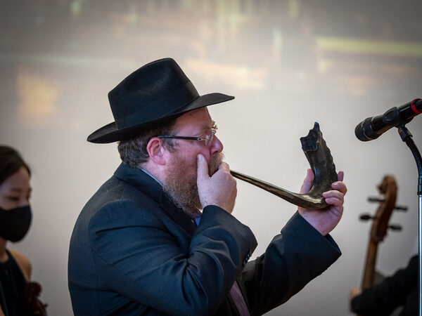 Rabbiner Shneor Havlin bläßt in ein Horn.
