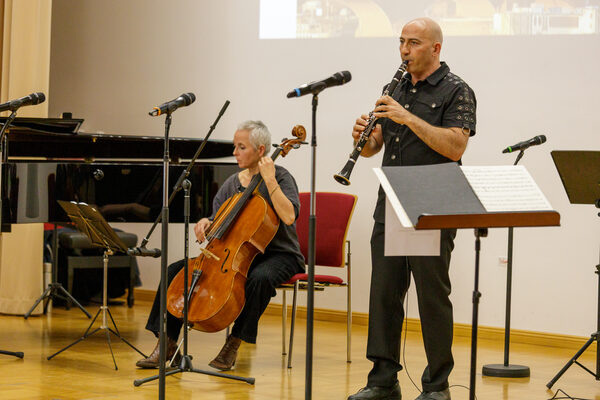 Dudu Zemach spielt Klarinette auf der Bühne, neben ihm sitzt Almut Mayer und spielt Cello.