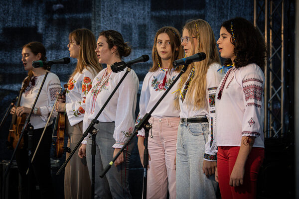 Sechs Mädchen singen auf der Bühne Lieder.