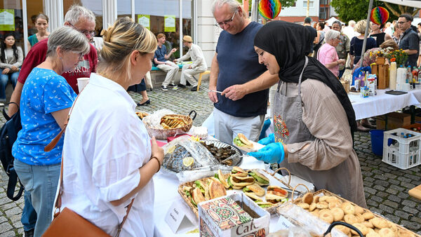 Besucherinnen nehmen sich Falafel Sandwiches beim Nachbarschaftsfest