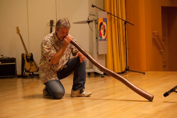 Mann spielt auf dem Didgeridoo