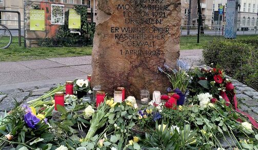Gedenkstein für Jorge Gomondai voller Blumensträuße und Kerzen