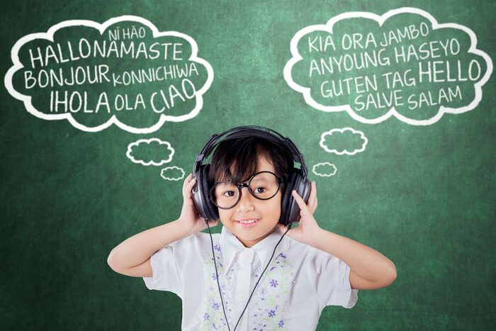 Eine Gruppe von kleinen Kindern sitz auf dem Boden und lernt mit einer Erzieherin