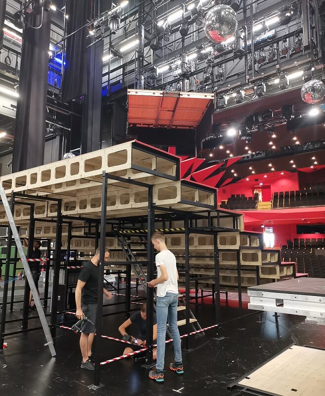 In der Staatsoperette unterstützt Karl die Angestellten der Bühnentechnik dabei, eine große Treppe für das abendliche Bühnenbild aufzubauen.