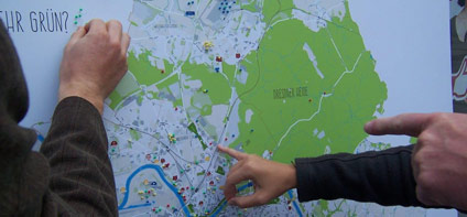 Hände markieren mit Stecknadeln Orte auf einer Dresden-Karte