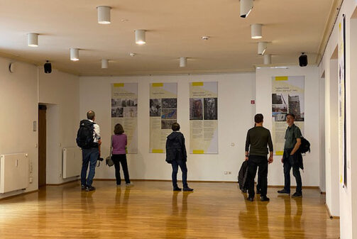 Besucher beim Betrachten der Ausstellung "Bewahren?! Mosaiken und keramische Wandflächen in der Denkmalpflege" im Kunstfoyer des Kulturrathauses