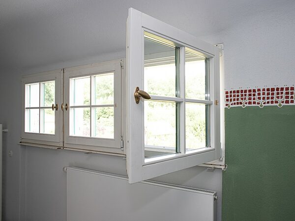 Fenster mit Originalgriff und Wandmalerei mit zweifarbig gerollter Bordüre