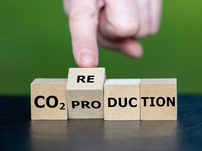 Vier beschriftete Holzwürfel stellen die Veränderung des Begriffs "CO2-Produktion" zu "CO2-Reduktion" dar.