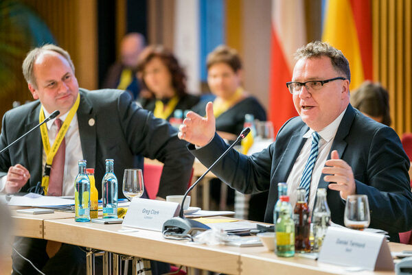 Oberbürgermeister Dirk Hilbert verfolgt Redebeitrag von Moderator von Greg Clark