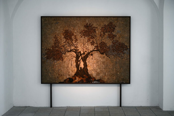 Foto eines Moasikwerkes, abgebildet ist ein brauner Baum