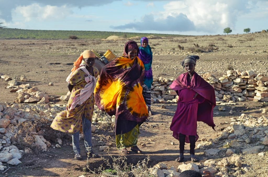 eine Gruppe von Frauen in schönen traidtionellen Gewändern in ausgetrockneter Landschaft in der Somali-Region in Äthiopien