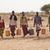Männer mit Wasserkanistern auf dem Weg zur Wasserstelle in der von Dürre gezeichneten Landschaft
