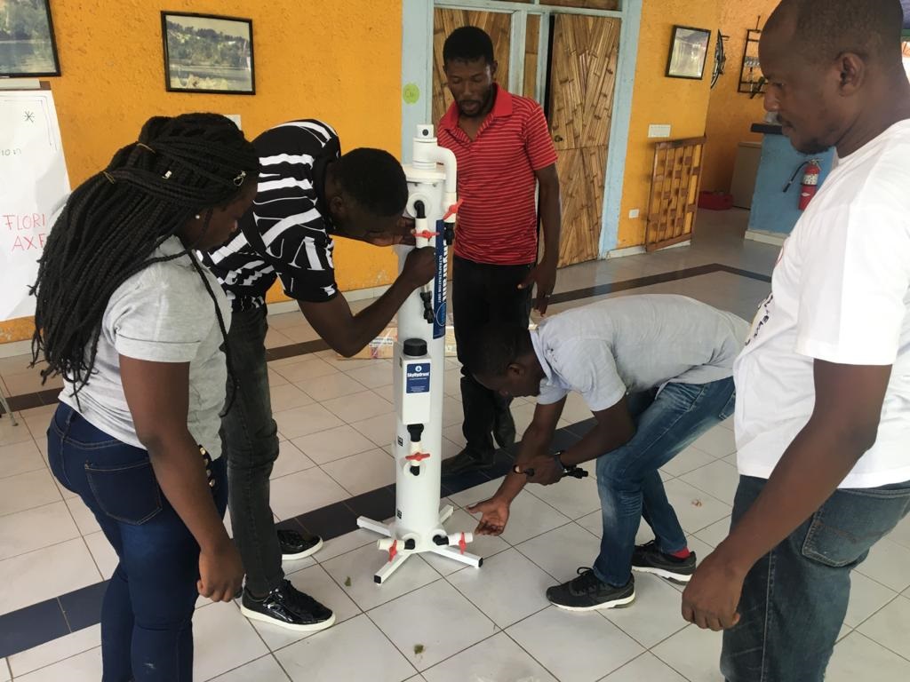 Team von Haitianern probiert eine Wasseraufbereitungsanlage aus