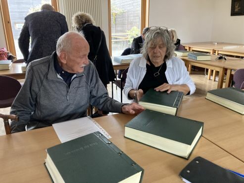 Zwei Personen sitzen vor Gedenkbüchern in der Jüdischen Gemeinde