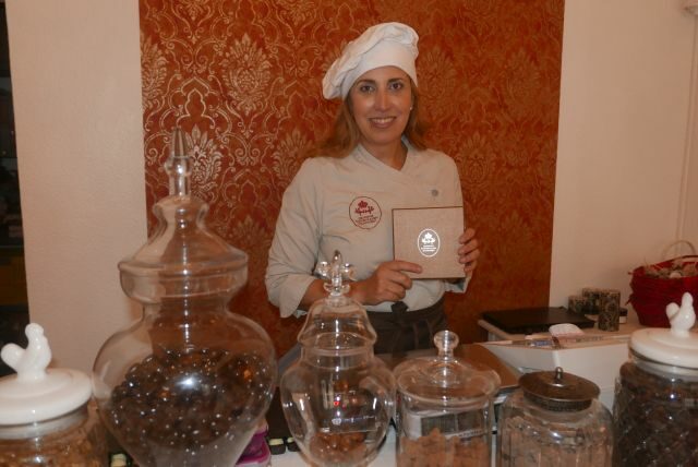 Amina Kühnel in ihrer Schokoladenmanufaktur, vor ihr Gläser mit Schokolade und Zutaten