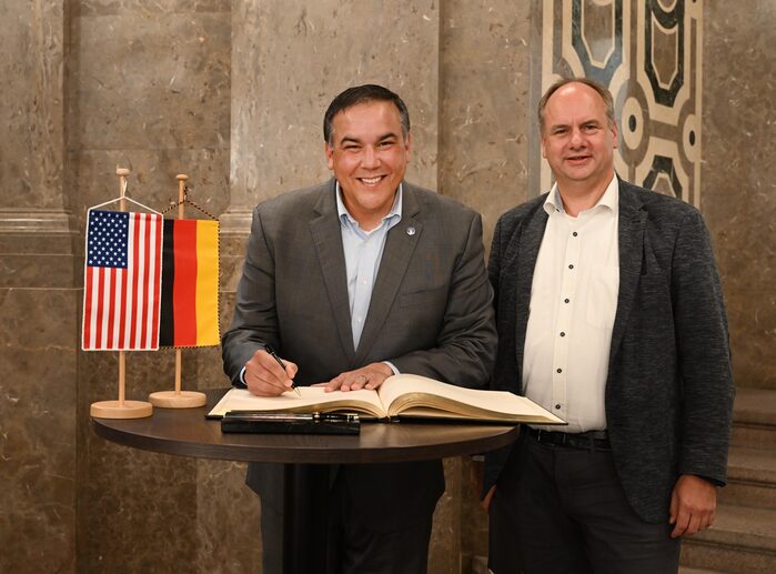 Der Bürgermeister aus Columbus trägt sich ins Goldene Buch der Stadt ein, daneben der Oberbürgermeister Dirk Hilbert