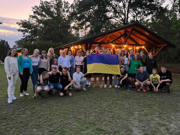 Gruppe von Kindern und Jugendlichen hält die ukrainische Flagge in der Hand