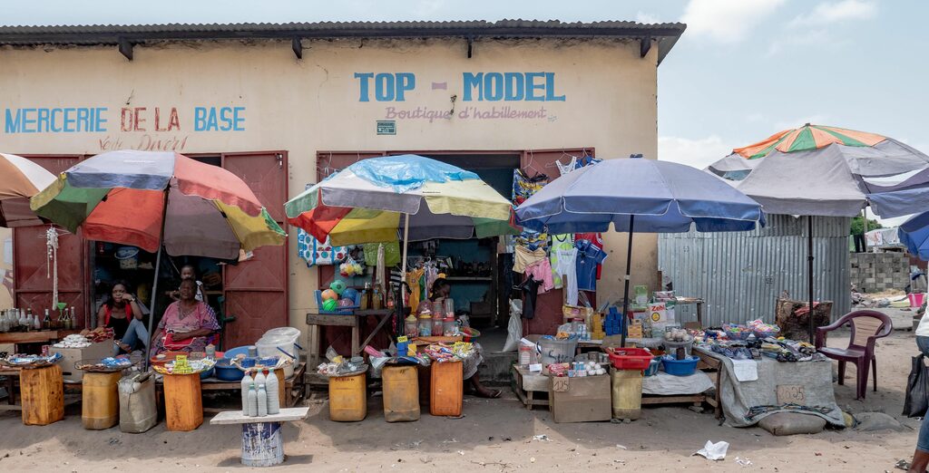 Verkaufsszene in Brazzaville, Frauen sitzen unter Sonnenschirmen und bieten ihre Waren an