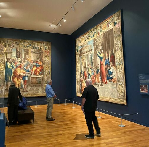 Blick auf zwei Teppiche im Ausstellungsraum, davor Personen, die sie anschauen