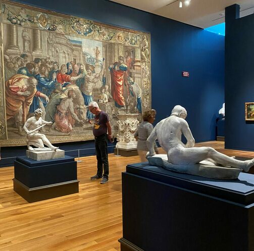 Marmorstatuen im Ausstellungsraum mit dem Teppich an der Wand