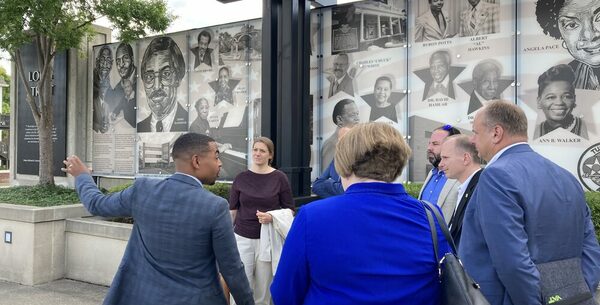 Stadtratspräsident Hardin zeigt der Gruppe die Kulturmauer, auf der an schwarze Persönlichkeiten der Stadt erinnert wird