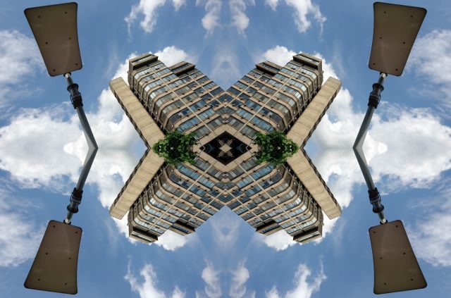 Fotografie mit einem Wohnhaus im Plattenbaustil im Himmel schwebend und gespiegelt