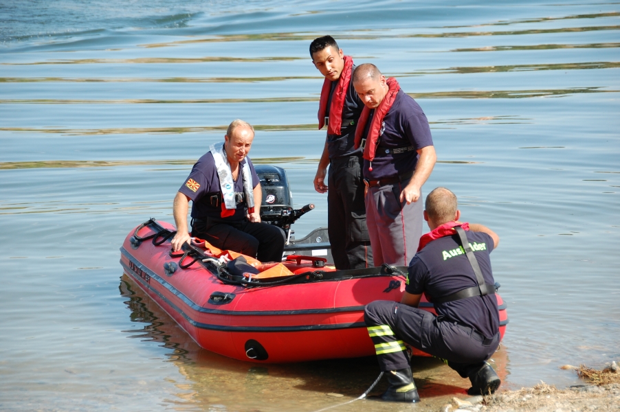 vier Männer mit Schlauchboot am Flussufer